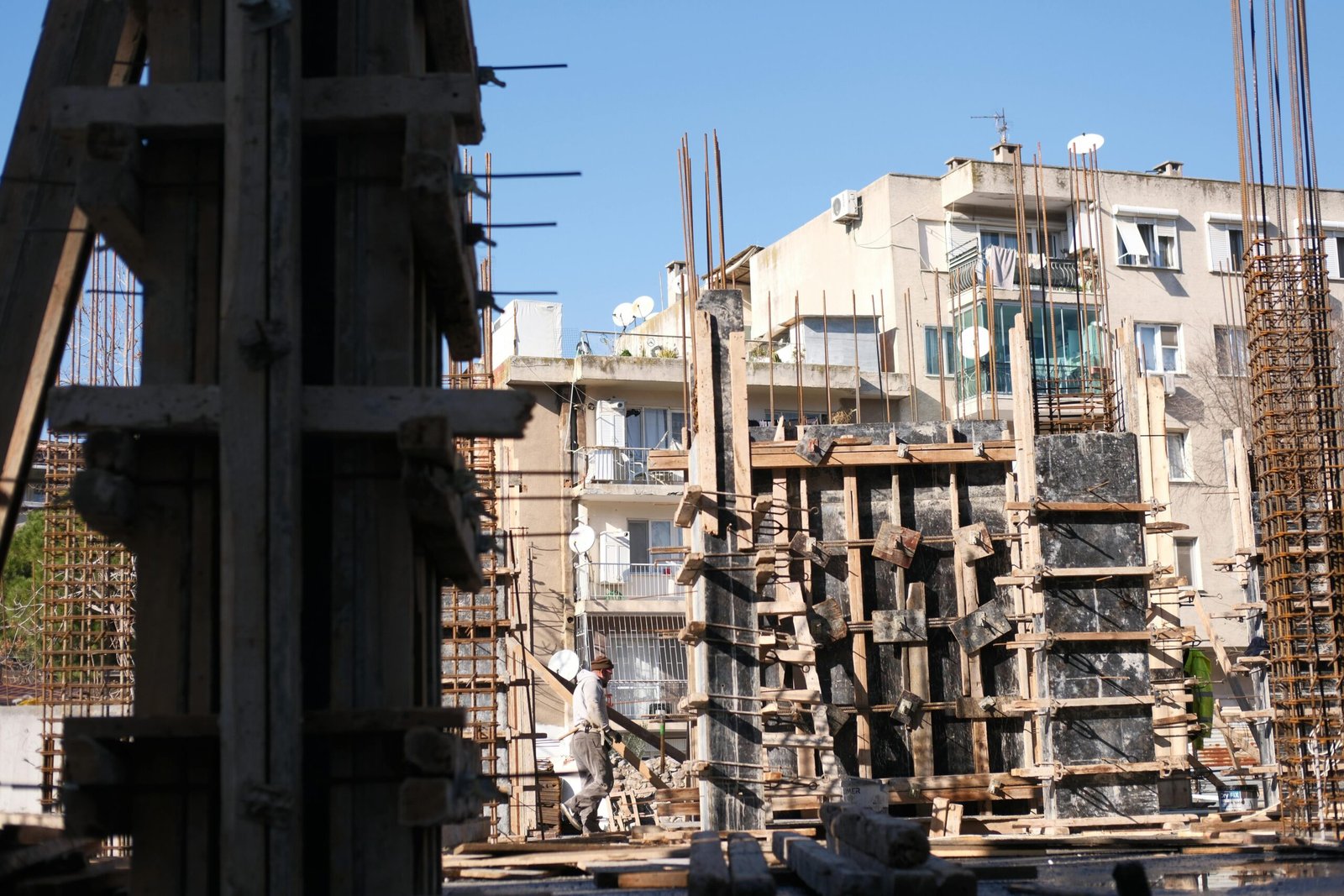 Concrete and steel construction site in İzmir, Türkiye with workers.